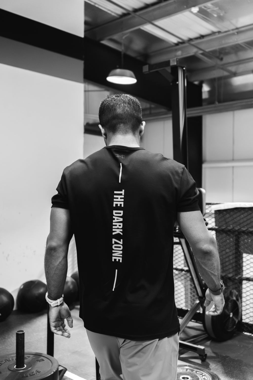 Coach in a Dark Zone shirt walking the gym floor