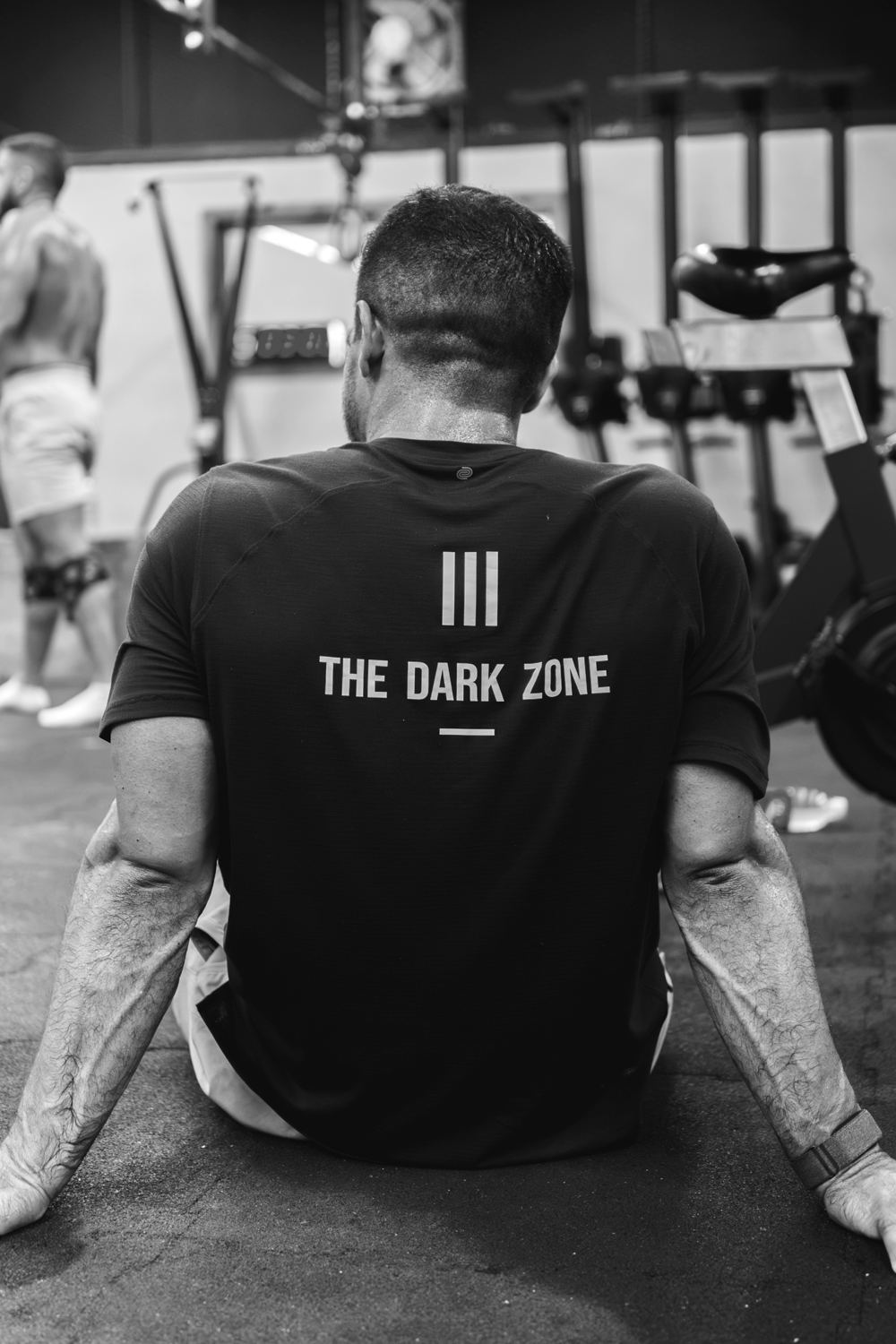 Athlete wearing a Dark Zone shirt, resting between sets