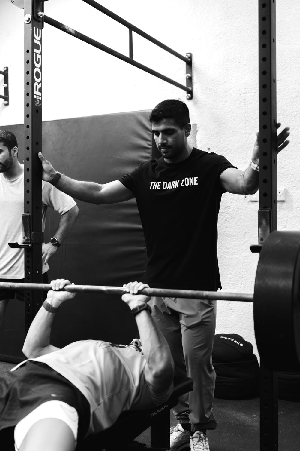Coach spotting an athlete on the bench press